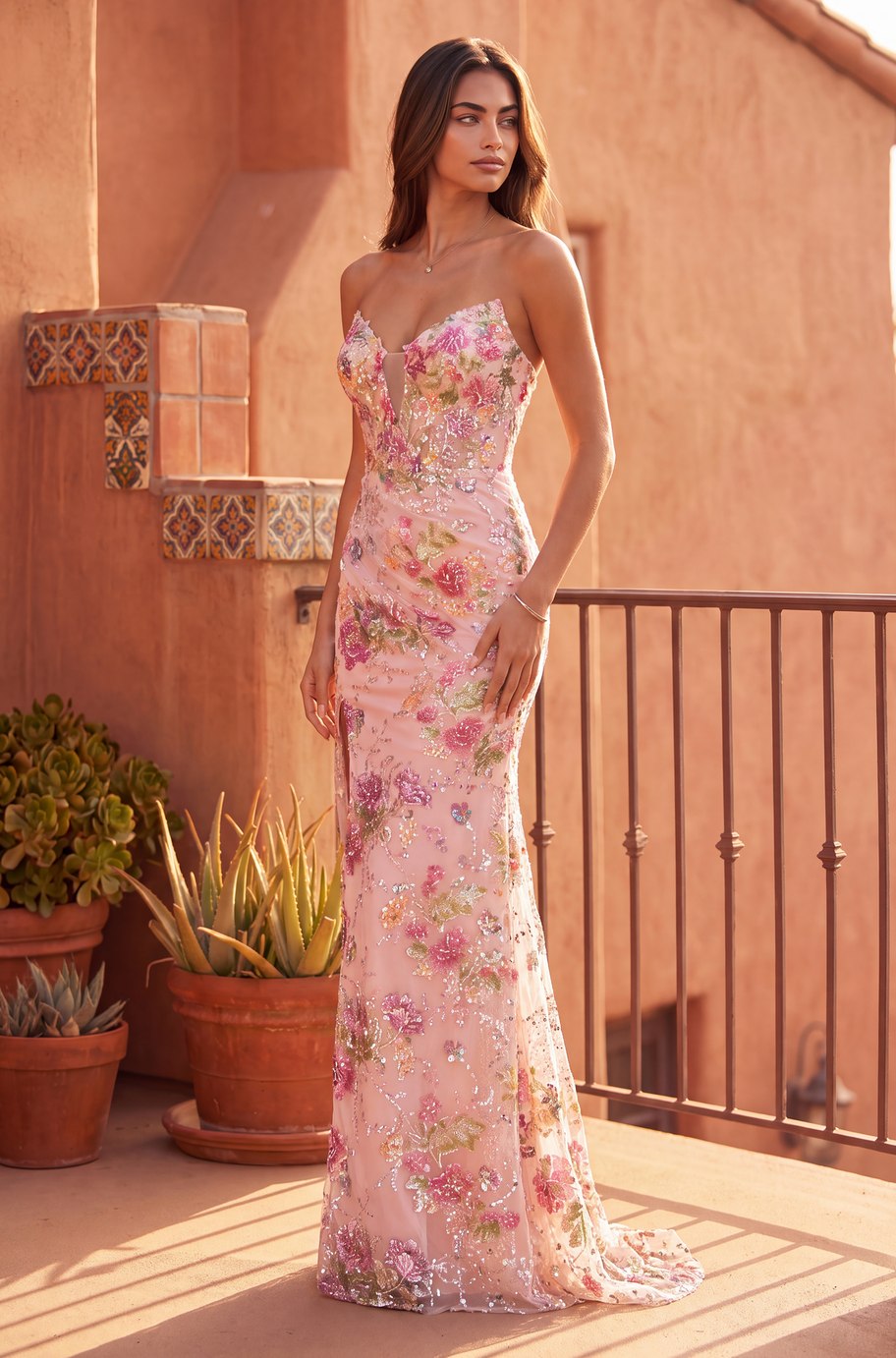 The Fiorella Gown — rose embroidered sequin gown with strapless plunge bodice, fitted silhouette and sweep train, front view at golden hour