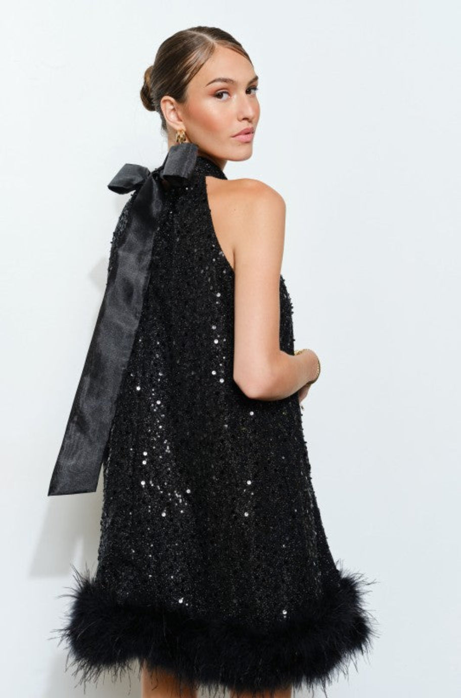 Black sequin halter mini dress with satin bow and feather trim hem