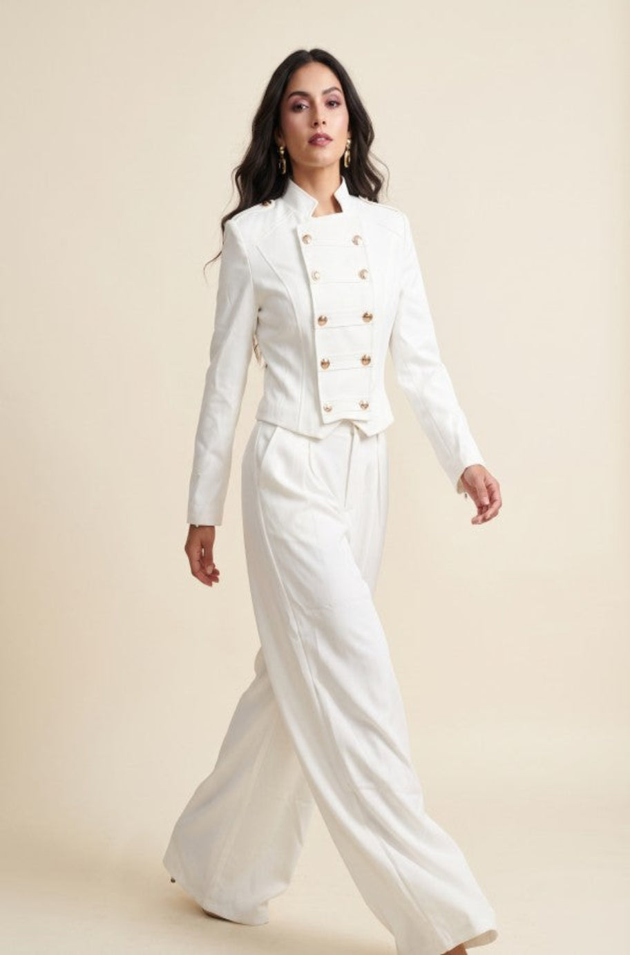 White cropped military jacket with gold buttons and wide-leg trousers