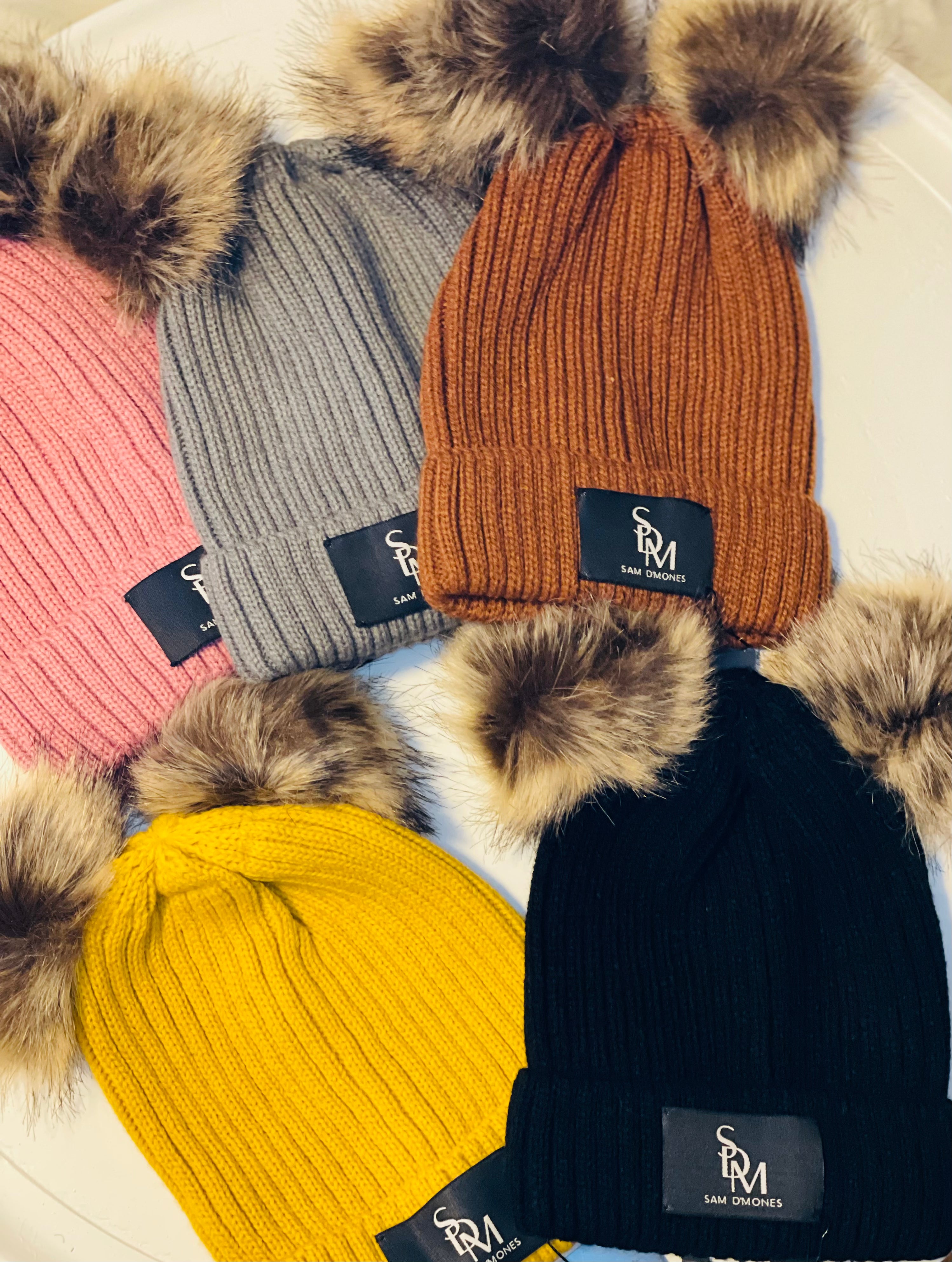 Knit beanie hats with pom poms in black, brown, pink, mustard and grey